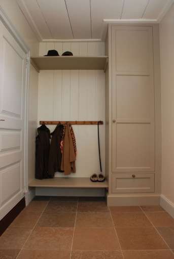 Platsbyggd garderob och platsbyggd hylla och skoställ gör sig bra i den här groventrén som ligger i anslutning till husets kök.