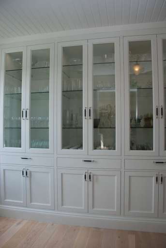 Platsbyggt vitrinskåp med luckor både med glas för att visa finporslinet, dold förvaring och lådor.